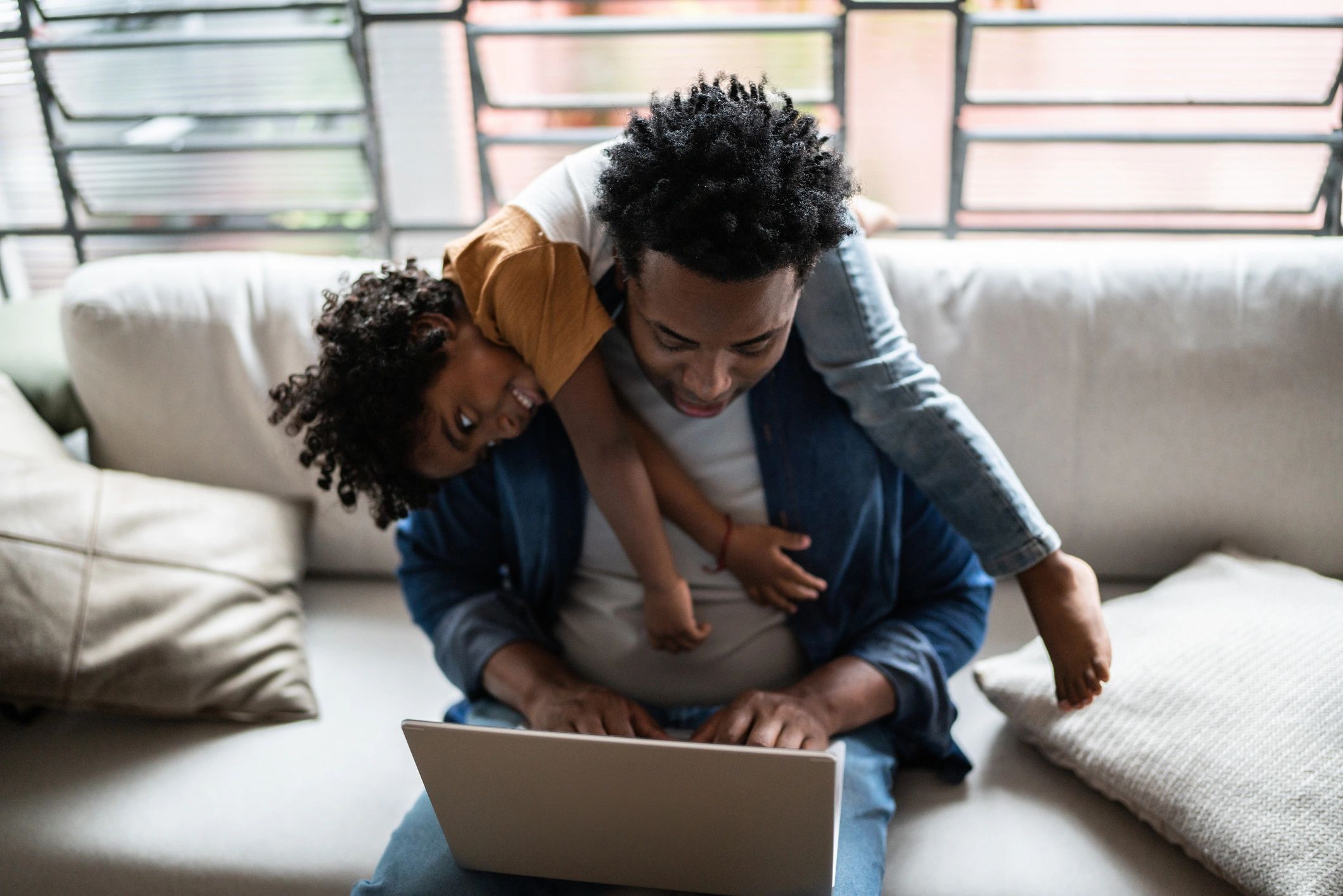 Parent and child using a laptop together at home