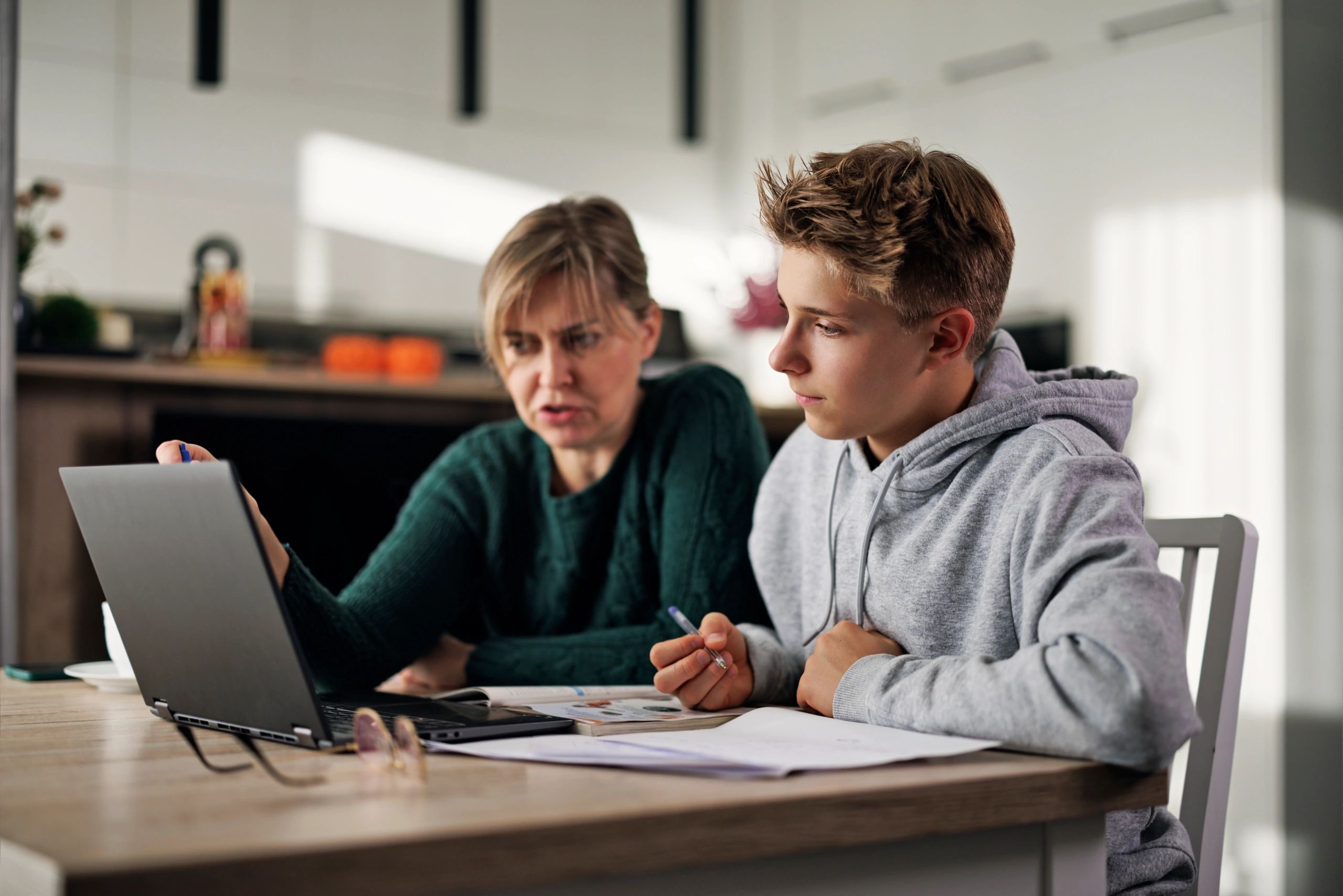 Mother helping son with homework at home