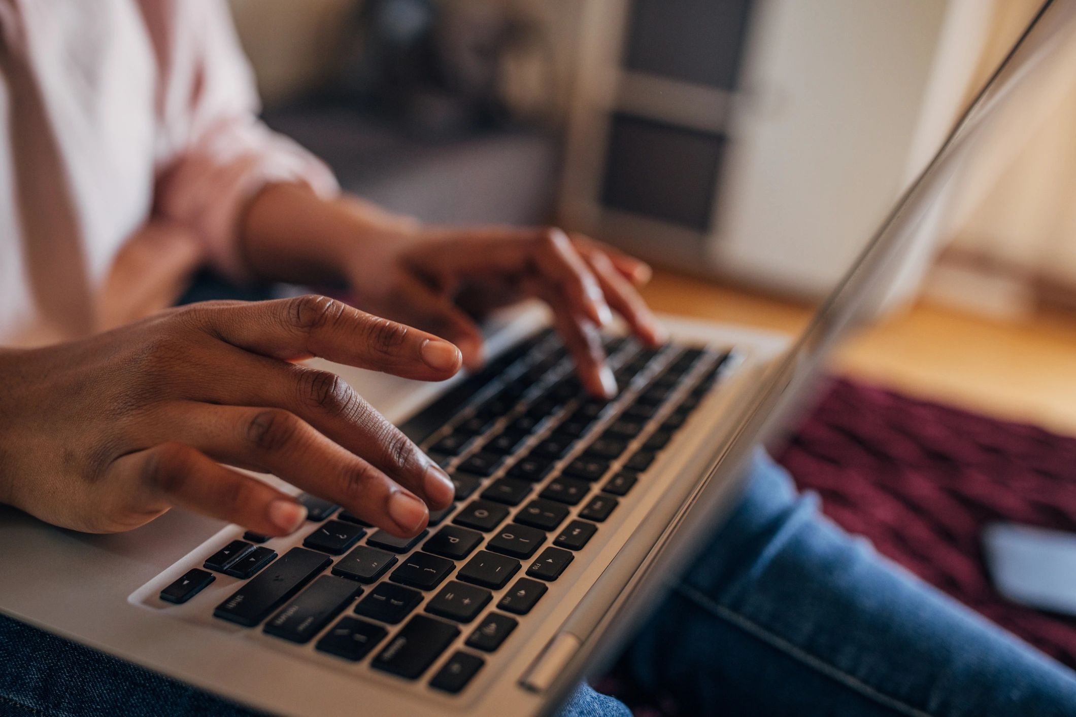 Primer plano de manos escribiendo en un teclado durante una lección
