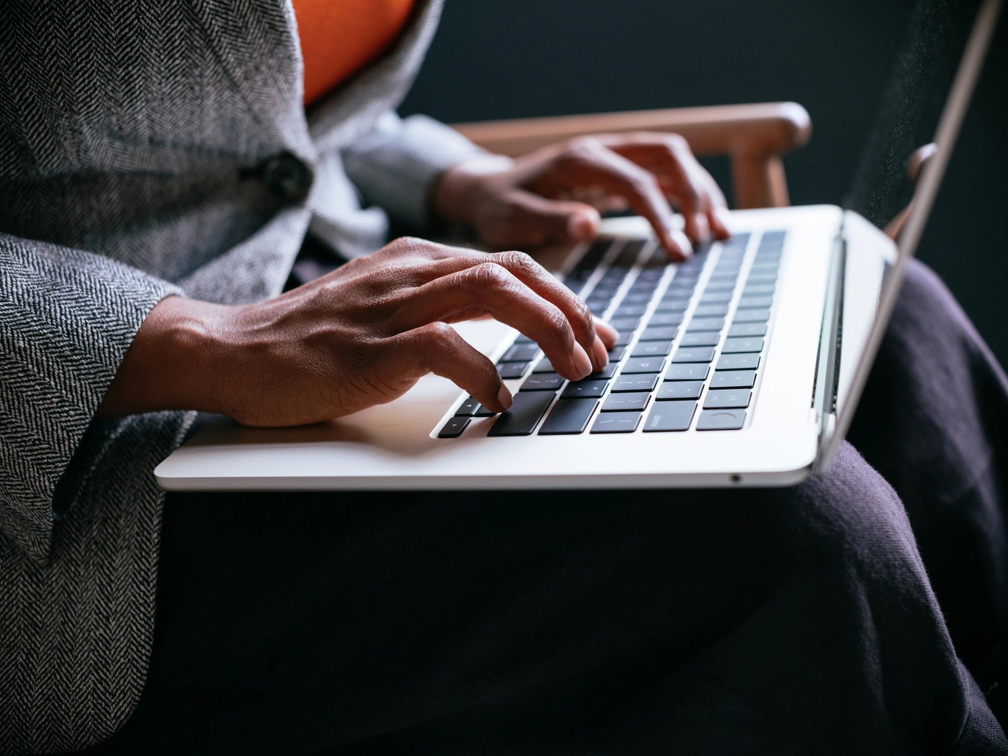 Close-up of hands typing on a laptop keyboard