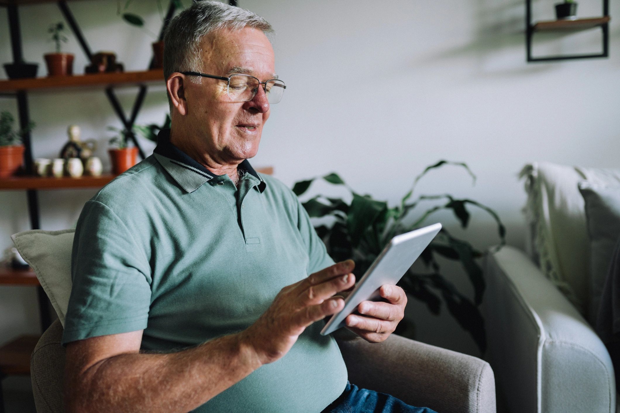 Senior man using a digital tablet in the living room