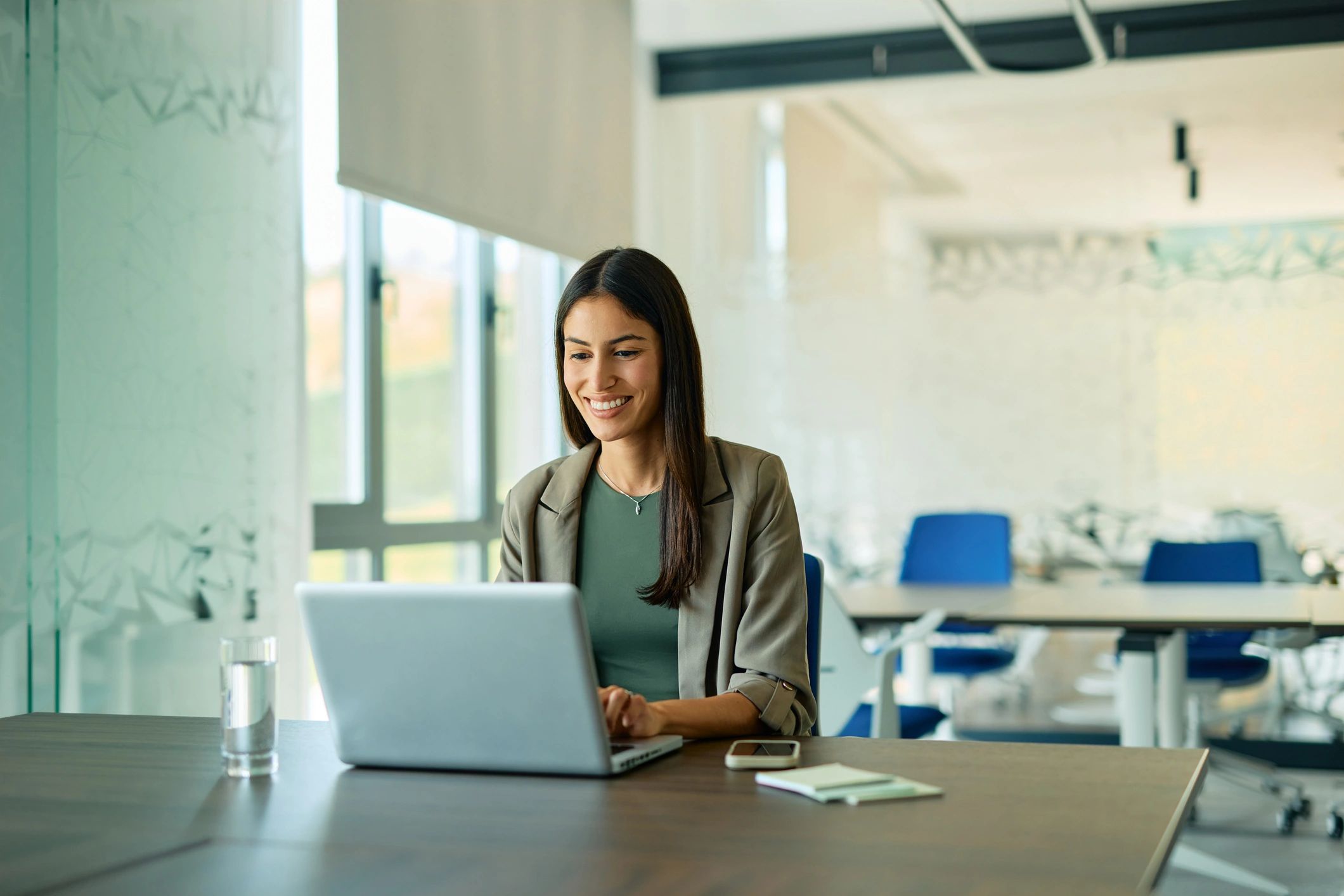 Young businesswoman working on laptop in modern office