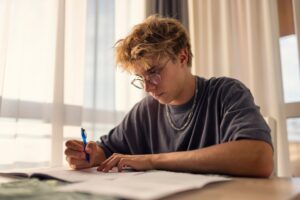 Medium shot footage of a teenage boy studying at home.