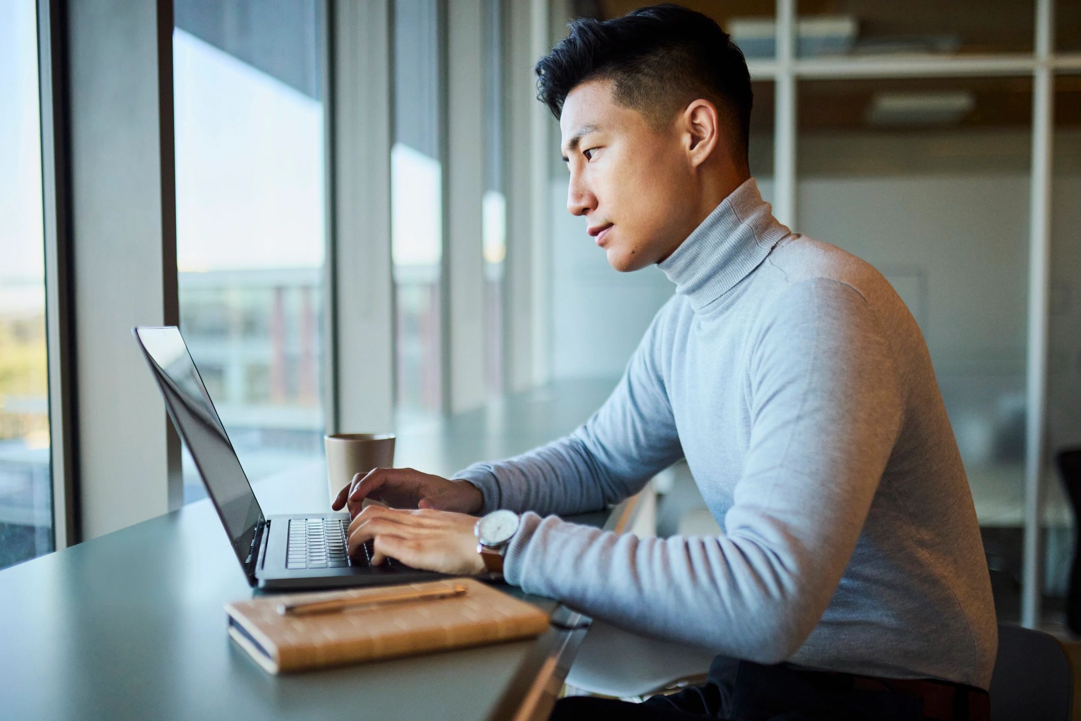 Professionnel concentré travaillant sur un ordinateur portable dans un bureau moderne